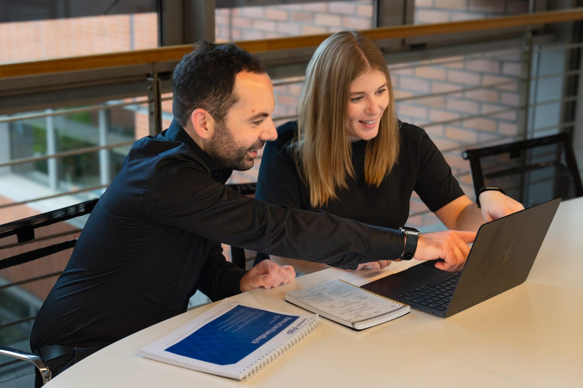 A man and woman working on a laptop to create venture growth programs